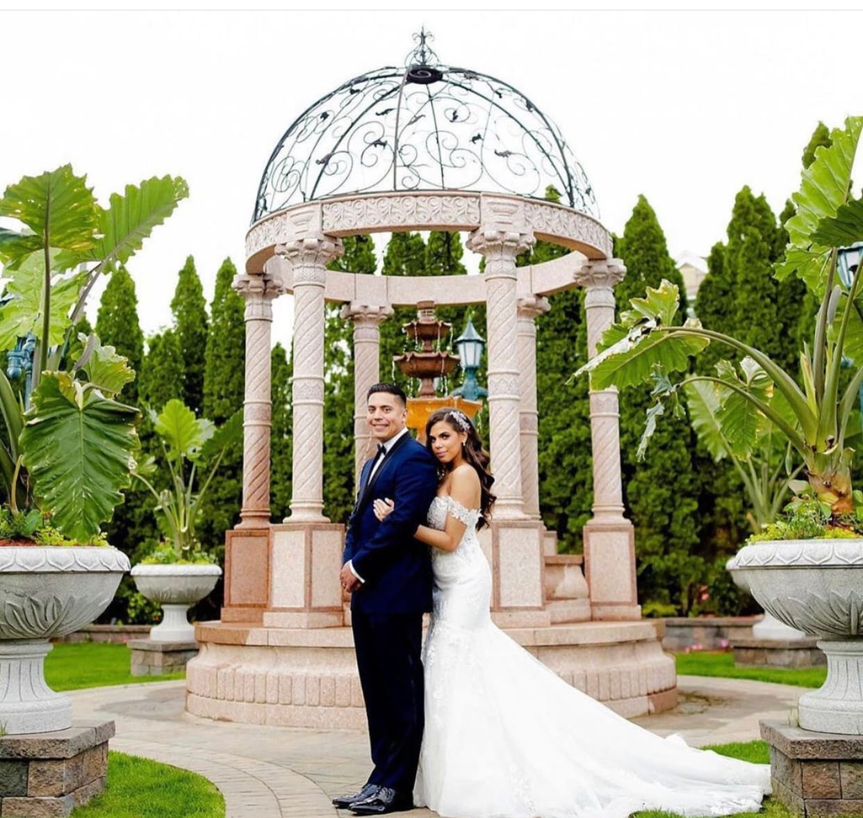 a bride and groom photo infront of a structure
