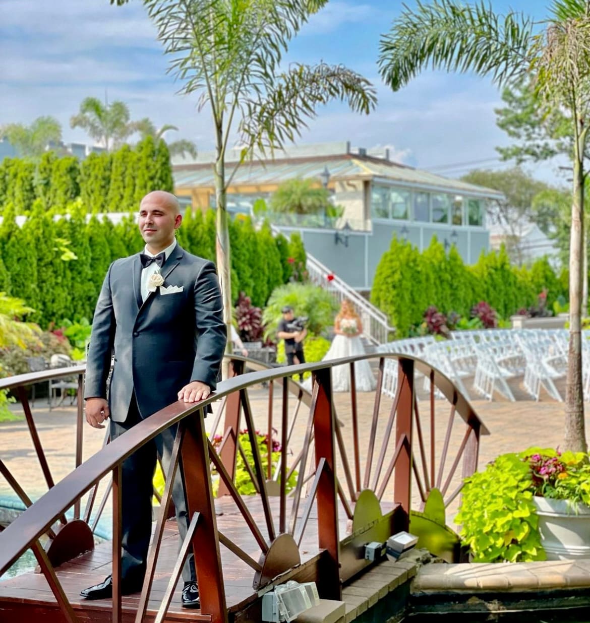 a groom taking a photo on a bridge
