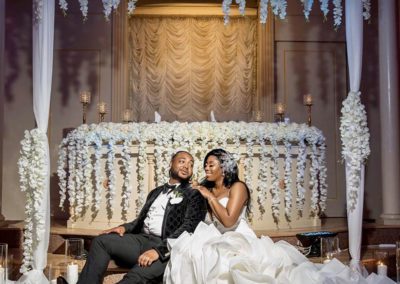 a bride and groom sitting infront of a decorated display