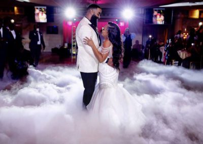 a bridge and groom dancing on the dance floor, with smoke effects around them on the floor