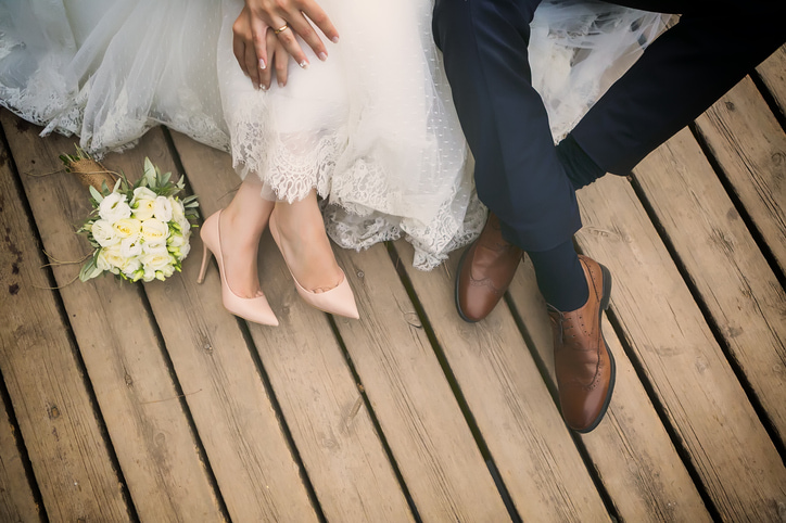 Couple bride and groom sitting on wooden floor